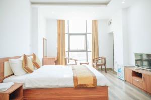 Schlafzimmer mit einem Bett, einem Schreibtisch und einem TV in der Unterkunft Sky Night Hotel Bắc Ninh in Bồ Sơn
