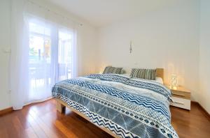 una camera da letto con un letto con una coperta blu e bianca di Apartment NB a Šilo Altre 20 foto