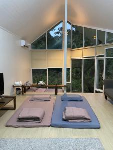 two beds in a room with large windows at Royal mountain view (วิวเขาหลวง) in Ratchaburi