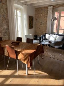un soggiorno con tavolo, sedie e divano di Piccolo Palazzo a San Felice del Benaco