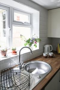 a kitchen counter with a sink and a window at Mount Pleasant Cottage Painswick in Stroud