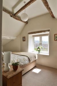 a bedroom with a bed and a window at Mount Pleasant Cottage Painswick in Stroud