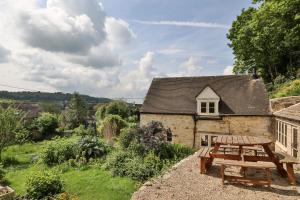 a picnic table in front of a cottage at Mount Pleasant Cottage Painswick in Stroud