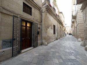an alley with a brown door on a building at Antica Cisterna di Lecce in Lecce