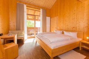 ein Schlafzimmer mit einem großen Bett und einem Fenster in der Unterkunft GutsAlm Harlachberg in Bodenmais