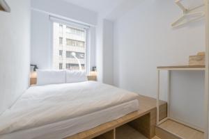 a white bedroom with a bed and a window at OwlStay Flip Flop Hostel - Garden in Taipei