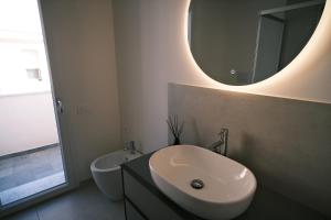 a white bathroom with a sink and a mirror at Casa Vacanze Derby Appartamenti in Misano Adriatico +19 photos