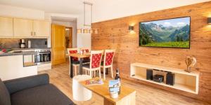 a living room with a couch and a table with chairs at Landhaus Dodel in Oberstdorf