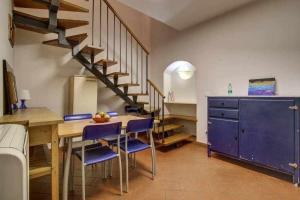 a dining room with a table and a staircase at Piazza Mentana Apartment in Florence