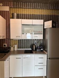 a kitchen with white cabinets and a stainless steel refrigerator at Apartments Villa Isabella in Opatija