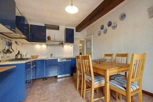 a kitchen with a wooden table and blue cabinets at Solaris Apartment With Two Bedrooms in Florence