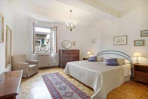 a bedroom with a bed and a chair and a window at Solaris Apartment With Two Bedrooms in Florence