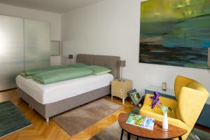 クラーゲンフルトにあるApartments Alter Platzのベッドルーム1室(ベッド1台、テーブル、ソファ付)