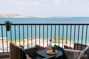 d'un balcon avec une table et des chaises donnant sur l'océan. dans l'établissement Stunning Seaviews. Prime Location. Lovely Home., à San Pawl il-Baħar