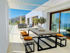 una sala da pranzo con tavolo e sedie su un patio di La Casa de Cristal - Alpujarra Escape a Órgiva Altre 41 foto