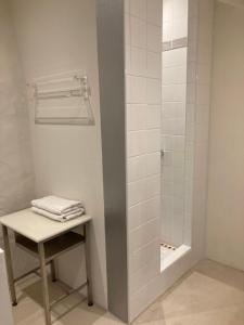 La salle de bains est pourvue d'une douche avec un tabouret et une table. dans l'établissement La Veillonnais, à Angrie