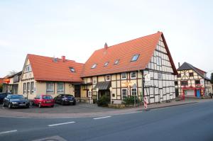 a building with cars parked in front of it on a street at Pension Schaumburger-Hof in Fischbeck