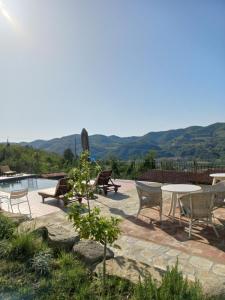a patio with a table and chairs and a pool at La Luna Buona in Vesime