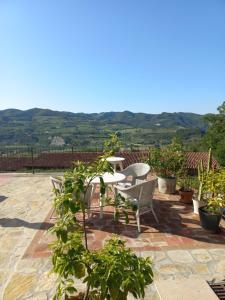 a patio with a table and chairs and plants at La Luna Buona in Vesime