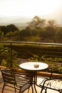 a table and two chairs on a balcony with a view at Bougain Villas in Chiang Dao