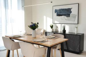 uma sala de jantar com uma mesa de madeira e cadeiras brancas em Lamzi's Residence em Chania Town