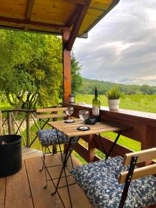 a table and chairs on a deck with a bottle of wine at The Treehouse of The Dragon in Ioannina