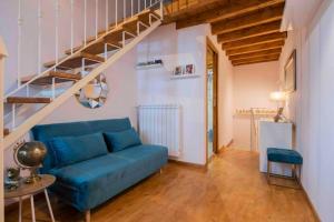 sala de estar con sofá azul y escaleras en La casa di Choco, en Nepi