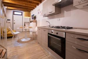 cocina con fogones, fregadero y mesa en La casa di Choco, en Nepi