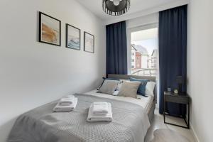 Un dormitorio con una cama con dos toallas encima. en Flatbook Apartamenty - Sztutowo Baltic Garden z Basenem i Parkingiem, en Sztutowo