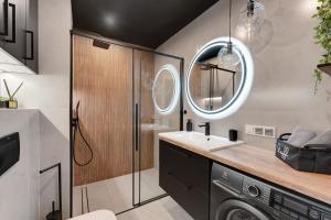 Un baño con lavabo y lavadora. en Flatbook Apartamenty - Sztutowo Baltic Garden z Basenem i Parkingiem, en Sztutowo 47 fotos más