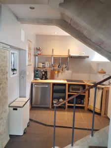 uma cozinha com utensílios de aço inoxidável e armários de madeira em La petite bajocasse em Bayeux