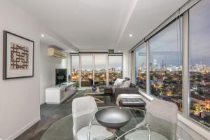 a living room with a view of a city at Exclusive Stays - Seven Yarra in Melbourne