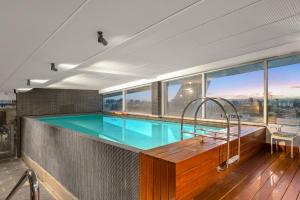 a swimming pool in a room with a large window at Exclusive Stays - Seven Yarra in Melbourne