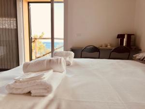 a white bed with towels sitting on top of it at Eufonia del Mare in Finale Ligure