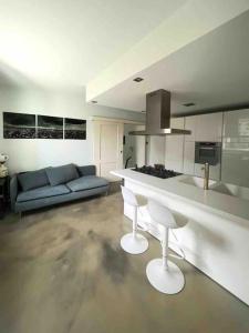 eine Küche und ein Wohnzimmer mit einem Sofa und einer Theke in der Unterkunft Villa Anna Onno Lake Como in Onno