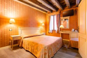 ヴェネツィアにあるランテルナ ディ マルコ ポーロのベッドとテレビが備わるホテルルームです。