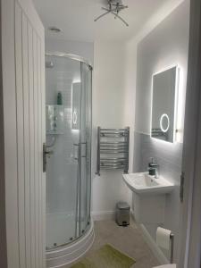 a white bathroom with a shower and a sink at Bowtree House Bed and Breakfast in Grantham