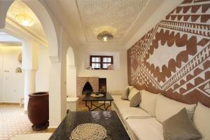 a living room with a couch and a fireplace at Riad Dar El Khir en centre ville rooftop et bassin in Marrakech