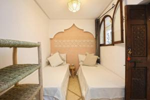 a room with two bunk beds and a staircase at Riad El Khir en centre ville rooftop et bassin in Marrakech
