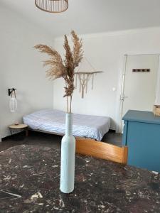 a white vase with a plant in it in a room at Charmant studio lumineux Florida plage in Canet-en-Roussillon