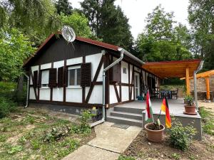 uma pequena casa a preto e branco com um alpendre em Regina Ranch em Igal