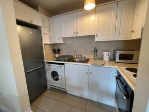 a kitchen with white cabinets and a sink and a dishwasher at Central Thomas Street in Dublin