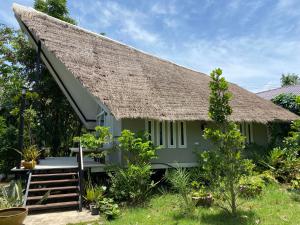 a small green cottage with a thatched roof at Royal mountain view Ratchaburi in Ratchaburi
