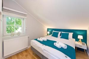 a bedroom with a large bed with two towels on it at Sopot Parkowa in Sopot