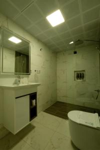 a bathroom with a tub and a sink and a mirror at Varyant Hotel in Konak