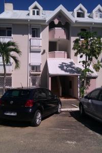 a black car parked in front of a house at Très Beau Studio tout équipé/Vu Mer/wiffi in Le Gosier