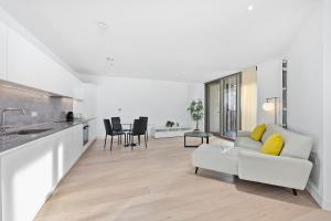 sala de estar con sofá blanco y cocina en Riverside View Apartments, en Londres
