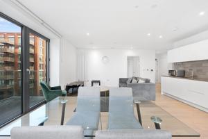 sala de estar con mesa de cristal y sillas en Riverside View Apartments, en Londres