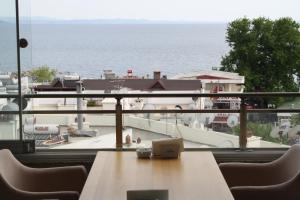 a table and chairs with a view of the ocean at Inciler Hotel in Altınoluk