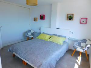 een slaapkamer met een bed en 2 stoelen bij GMID IMMO Apartamento Oasis in Roses